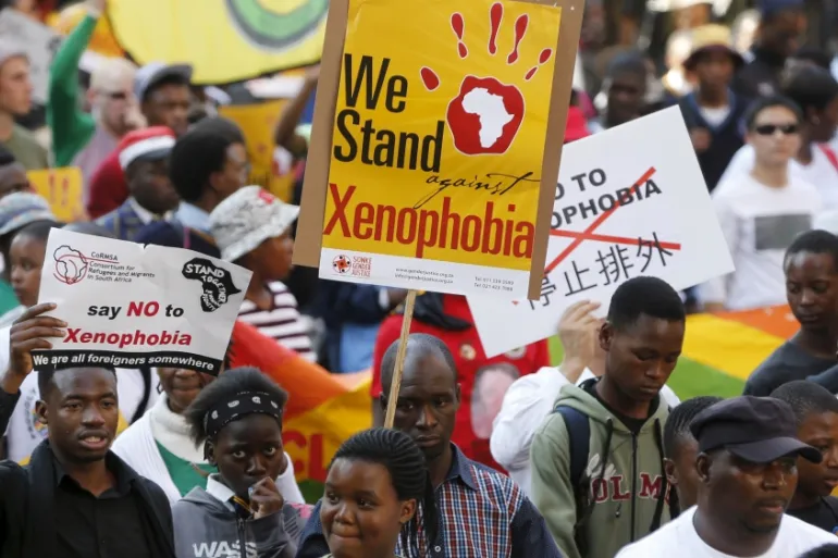 Demonstrators carry placards during a march against xenophobia in downtown Johannesburg [Reuters]