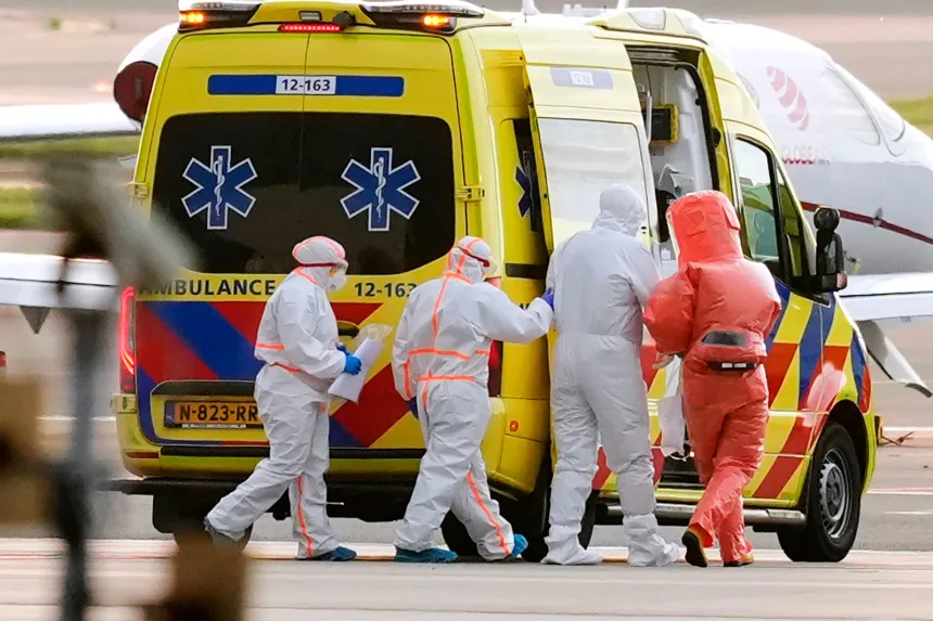 Medics escort a patient, second right, evacuated from the MV Hondius cruise ship with suspected hantavirus infection, to an ambulance after being flown to Schiphol airport, Amsterdam, Netherlands, on May 6. Peter Dejong/AP
