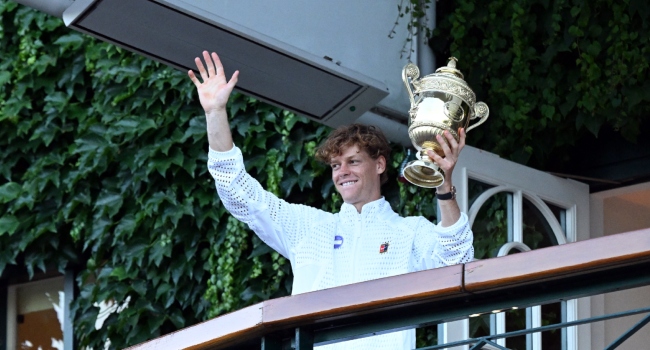 Italy’s Jannik Sinner waves from the balcony after winning the men’s singles final tennis match against Germany’s Alexander Zverev on the last day of the 2026 Wimbledon Championships at The All England Lawn Tennis and Croquet Club in Wimbledon, southwest London, on July 12, 2026. (Photo by Kirill KUDRYAVTSEV / AFP)