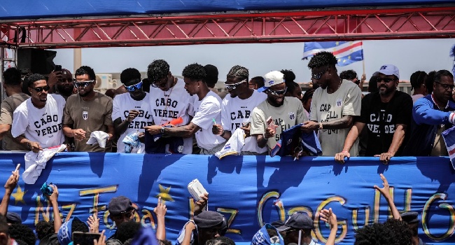 Cape Verde national football team players greet supporters from a bus upon their arrival in Praia on July 5, 2026, after competing at the 2026 FIFA World Cup. (Photo by Jose Correia / AFP)