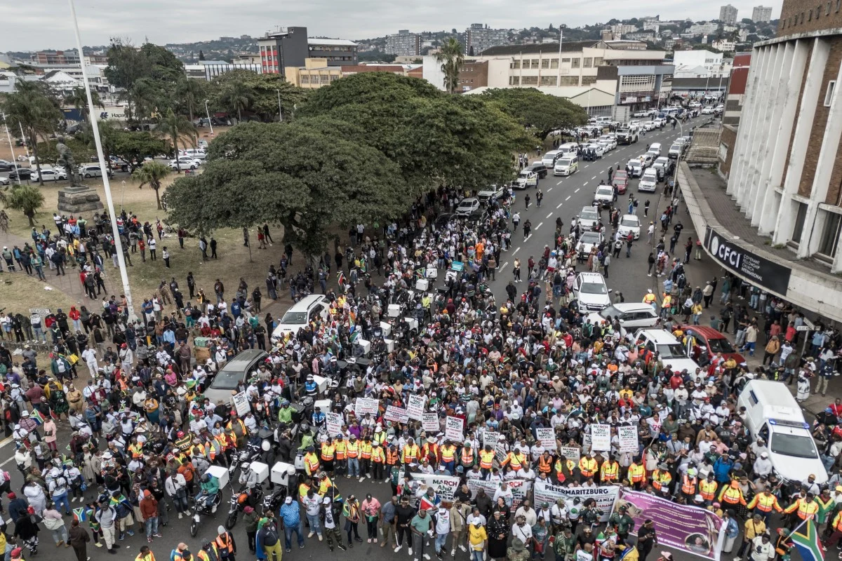 An aerial view of protesters marching during a demonstration by the "March and March" movement marking an unofficial deadline set by citizen-led groups for undocumented foreign nationals to leave South Africa, in Durban, on June 30, 2026. Photo by MARCO LONGARI / AFP