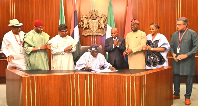 Tinubu (seated) signed the bill on Friday, jUNE 26, 2026.